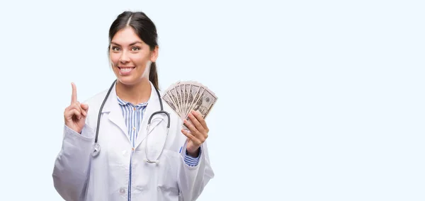 Young Hispanic Doctor Woman Holding Dollars Surprised Idea Question Pointing — Stock Photo, Image