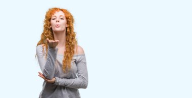 Bir öpücük el ile güzel ve seksi olmak hava üfleme kamera arayan genç Kızıl saçlı kadın. Aşk ifade.