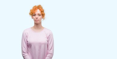 Yüzünde ciddi bir ifade ile genç Kızıl saçlı kadın. Basit ve doğal kameraya bakıyor.