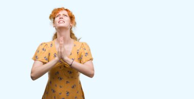 Yalvarıyor ve umut ifade yüzünde çok duygusal ve endişe ile birlikte elleriyle dua genç Kızıl saçlı kadın. Bağışlanmak. Din kavramı.