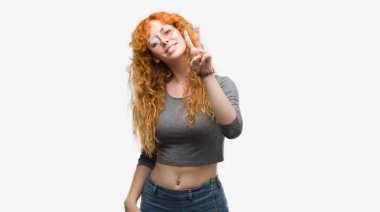 Zafer işareti yapıyor parmak gösterilen kamera seyir gülümseyen genç Kızıl saçlı kadın. İki numaralı.