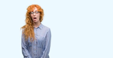 Genç redhead bussines kadın korkuyor ve sürpriz ifade, korku ve heyecan yüz ile şok.