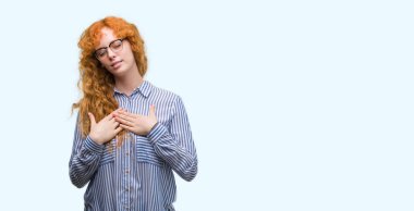 Genç redhead iş kadın kapalı gözler ile göğüs ellerinde ve yüzünde minnettar jest ile gülümseyen. Sağlık kavramı.