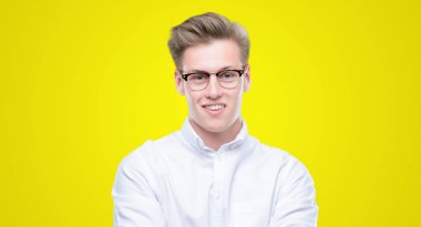 Genç yakışıklı sarışın adam mutlu yüz ile gülümseyerek kameraya seyir silah geçti. Olumlu bir kişi.