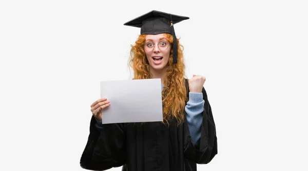 若い赤毛の女性誇りに思って叫んでと勝利と非常に興奮して 成功を祝っての学位を保持する大学院の制服を着て感情を応援 — ストック写真