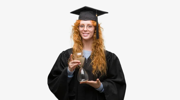 Giovane Studentessa Rossa Con Indosso Uniforme Graduata Che Tiene Clessidra — Foto Stock