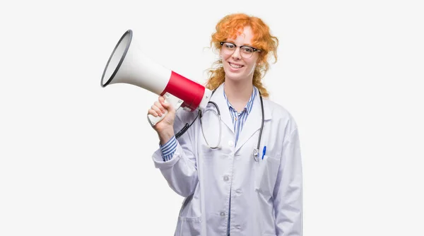 Νέοι Κοκκινομάλλα Γυναίκα Γιατρός Κρατώντας Μεγάφωνο Ένα Χαρούμενο Πρόσωπο Στέκονται — Φωτογραφία Αρχείου