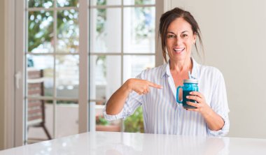 Kendini parmakla sürpriz yüz kadın içme milkshake bir cam orta yaşlı