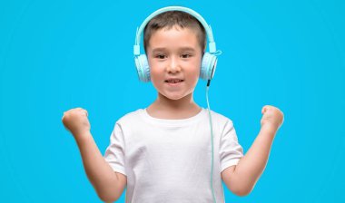 Koyu saçlı küçük çocuk müzik dinleme gurur çığlık ve zafer ve başarı çok heyecanlı, duygu tezahürat kutluyor kulaklıklar ile