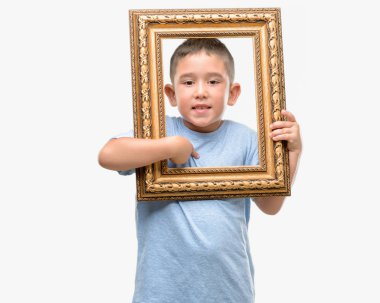 Koyu saçlı küçük çocuk kendisine sürpriz yüz işaret parmağı çerçeve holding