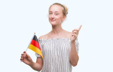 Almanya bayrağı tutan sarışın genç kadın bir fikir ya da soru işaret parmağı gülen yüz, bir numara ile şaşırttı