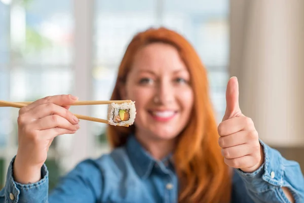 Ruda Kobieta Jedzenie Sushi Pomocą Pałeczki Szczęśliwy Uśmiechem Robi Znak — Zdjęcie stockowe