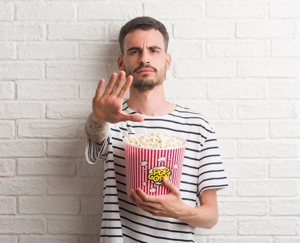 Jonge Volwassen Man Eten Popcorn Staande Witte Bakstenen Muur Met — Stockfoto