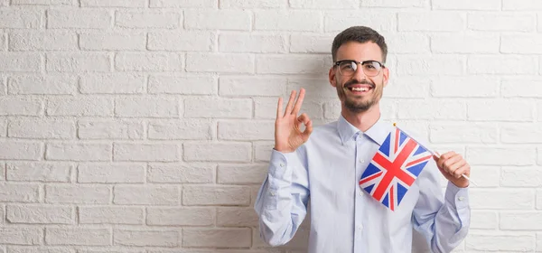 Homem Adulto Jovem Sobre Parede Tijolo Segurando Bandeira Reino Unido — Fotografia de Stock