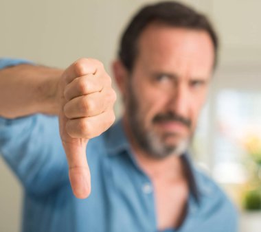 Yakışıklı orta yaş adam kızgın yüzü, eksi işareti aşağı antipati başparmak ile gösterilen, ret kavramı ile