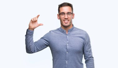 Gülümseyen bardakları ve süre seyir ve kamera boyutu işaret parmaklarıyla yapıyor el ile kendine güvenen el hareketi zarif yakışıklı genç. Ölçü kavramı.