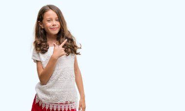 Esmer Latin kız neşeli bir gülümseme ile el ve parmak kadar kameraya bakarak yüzündeki mutlu ve doğal ifade ile yan ile işaret eden yüz.