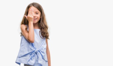 Esmer İspanyol kız yüz ve sürpriz duygu kendinden emin gülümseme ile el ile bir göz kapsayan.