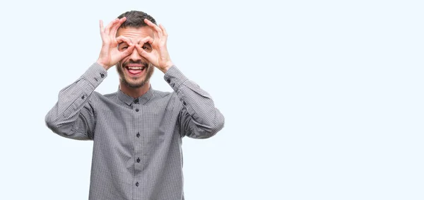 Joven Hipster Haciendo Buen Gesto Como Binoculares Sacando Lengua Ojos —  Fotos de Stock