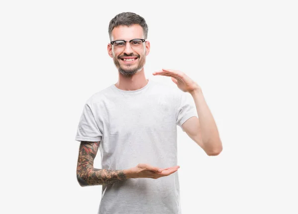 年轻的纹身成年男子手势与手显示大和大尺寸标志 测量符号 微笑着看着相机 测量概念 — 图库照片