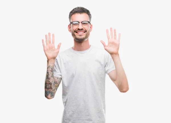 年轻的纹身成人男子显示和指着手指数十 而微笑着自信和快乐 — 图库照片