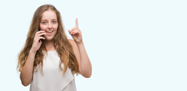 幸せそうな顔 ナンバーワンのアイデアや質問ポインティング指で驚きのスマート フォンを使用して若いブロンドの女性 — ストック写真