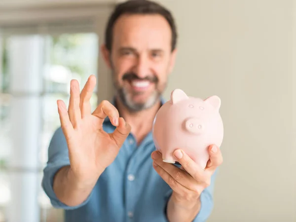 Mann Mittleren Alters Spart Geld Auf Sparschwein Tun Zeichen Mit — Stockfoto