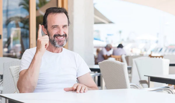 Bonito Homem Sênior Sentado Terraço Surpreso Com Uma Ideia Pergunta — Fotografia de Stock