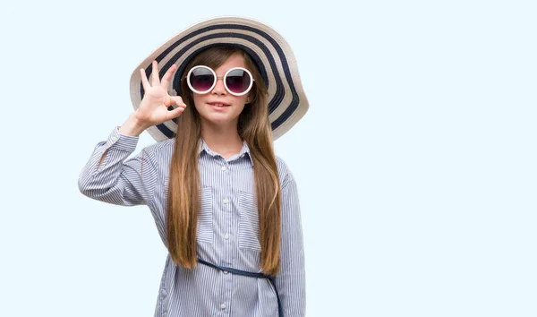 年轻的金发小孩戴着帽子和太阳镜做 标志与手指 优秀的标志 — 图库照片