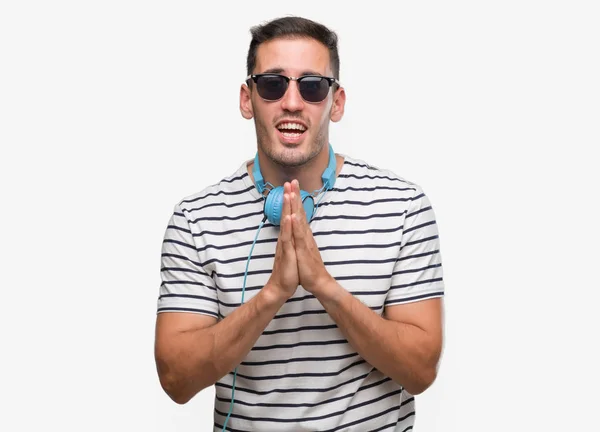 Joven Guapo Con Auriculares Mendigando Rezando Con Las Manos Juntas —  Fotos de Stock