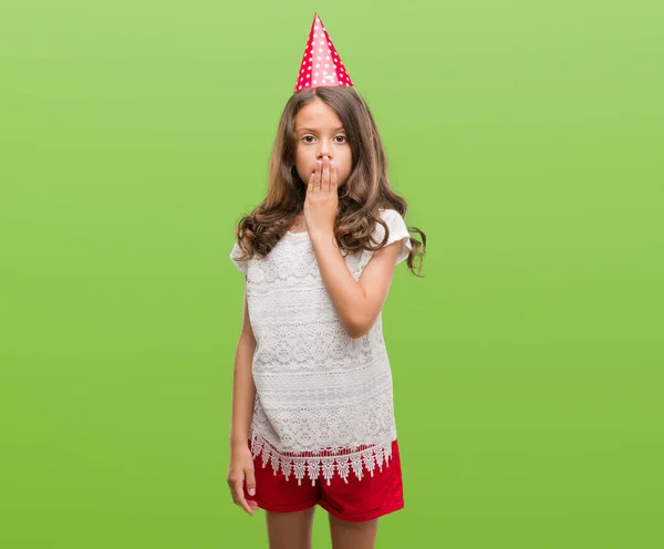 沈黙の中 秘密の概念で間違い 恐怖の表現のための恥とショックを受けた手で誕生日帽子カバー口を身に着けているヒスパニック系のブルネットの女の子が怖がっています — ストック写真