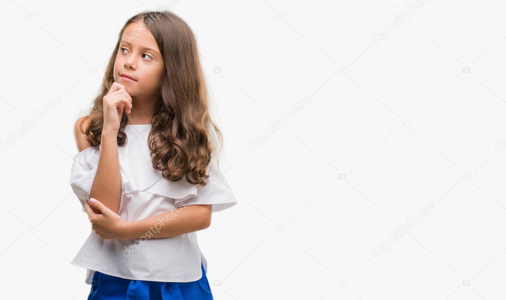 Brunette hispanic girl with hand on chin thinking about question, pensive expression. Smiling with thoughtful face. Doubt concept.