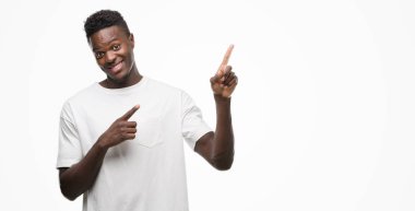 Genç Afro-Amerikan adam giyen beyaz gömlek gülümseyen ve iki elleri ve parmakları ile tarafına işaret kamera bakıyor.