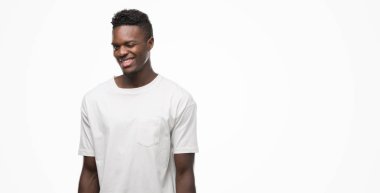 Beyaz t-shirt göz kırpıyor seksi bir ifadeyle, neşeli ve mutlu yüzünü kameraya bakarak giyen genç Afro-Amerikan adam.