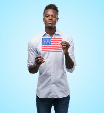 ABD bayrağı kendine güvenen bir ifade ile acımak yüz ciddi düşünüyorum tutan genç Afro-Amerikan adam