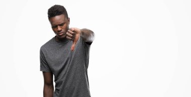 Mutsuz ve kızgın ret gösterilen ve başparmak aşağı hareketi ile negatif seyir gri t-shirt giyen genç Afro-Amerikan adam. Kötü ifade.