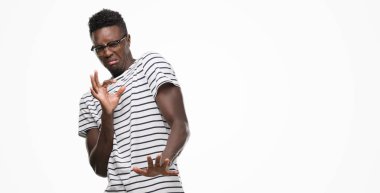 Gözlük ve lacivert t-shirt giyen genç Afro-Amerikan adam tiksinti ifadesi, memnun ve korkulu tiksinti yüz yapıyorsun çünkü nefret tepki. Elleriyle kaldırdı. Sinir bozucu kavramı.