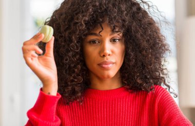 Macaron acımak yüz ciddi düşünüyorum üstünde kendine güvenen bir ifade ile tutan Afrikalı-Amerikalı kadın