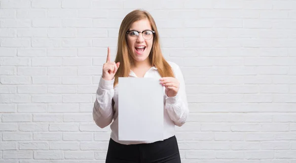 Jonge Volwassen Zakenvrouw Permanent Witte Bakstenen Muur Holding Blanco Papier — Stockfoto