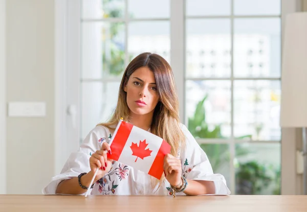 Jovem Mulher Casa Segurando Bandeira Canadá Com Uma Expressão Confiante — Fotografia de Stock