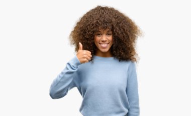 Afrikalı-Amerikalı kadın hareketi el ile mutlu yaşasın yapıyor bir kazak giyiyor. Kameraya bakarak başarı gösteren ile ifade onaylama.