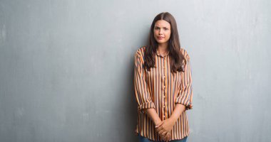 Kızgın ve korkmuş ağlıyor genç esmer kadın depresif grunge gri duvar ve sıkıntı, endişe. Üzgün ifade.