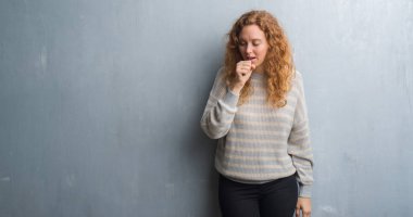 Genç Kızıl saçlı kadın hasta ve soğuk veya bronşit için semptom olarak öksürük duygu gri grunge duvarın üzerinden. Sağlık kavramı.