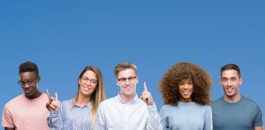 Grup üzerinde gösterilen ve kendinden emin ve mutlu gülümseyen bir parmak ile işaret eden oktan yukarı mavi blackground arkadaşıyla bileşimi.
