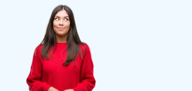 Kırmızı kazaklı görünümlü yan ve dik dik bakma uzağa düşünce gülümseyen giyen genç güzel İspanyol.