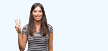 Gösterilen ve parmakları ile işaret genç güzel İspanyol kadın kendinden emin ve mutlu gülümseyerek iken üçüncü.