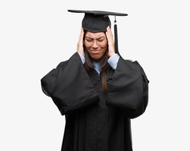 Giyen genç İspanyol kadın mezun kap ve baş ağrısı umutsuz ve stresli Tekdüzen acı çünkü ağrı ve migren. Ellerini kafasına.