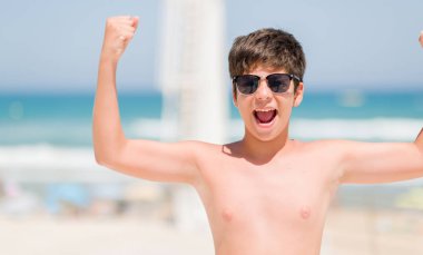 Genç çocuk rahatsız sahilde tatil ve boşa çıkarmak ile öfke, çılgın ve yükseltilmiş eliyle diye bağıran öfke kavramı bağırarak.