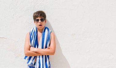 Tatillerde bir sürpriz yüz, korkuyor ve heyecanlı korku ifadesi ile şok korkmuş bir donanma havlu giyen genç çocuk