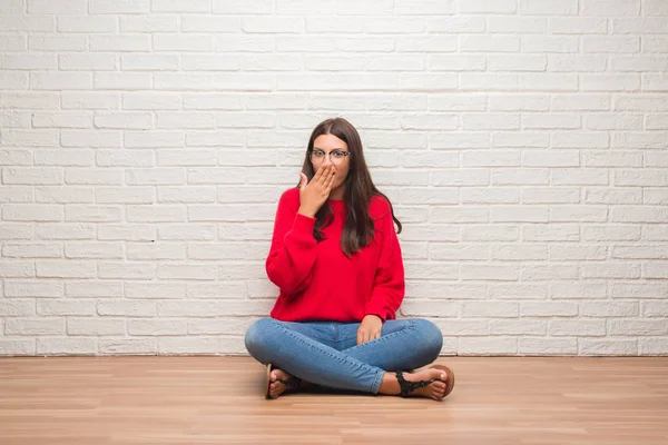 Junge Brünette Frau Sitzt Auf Dem Boden Über Weißem Ziegelmauerwerk — Stockfoto